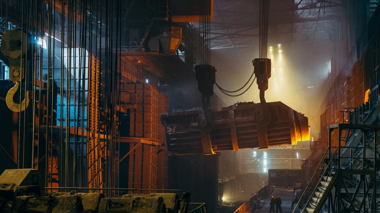 Recipiente industrial suspenso em ambiente metalúrgico — imagem editorial representativa do setor